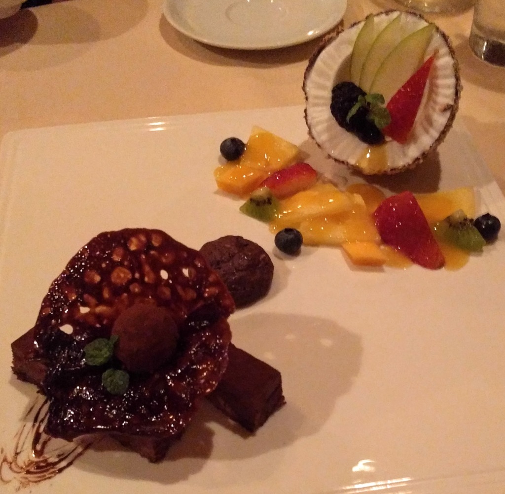 half a coconut stuffed with vanilla ice cream and fresh fruit and a chocolate crunch bar shaped like a turtle.