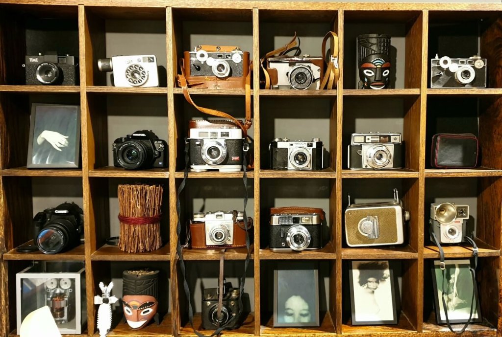 Several antique film cameras on a shelf.